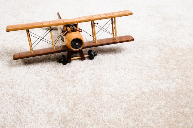 Foto houten vliegtuig op het tapijt