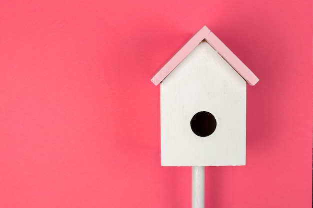 Houten vogelhuisje op roze bovenaanzicht