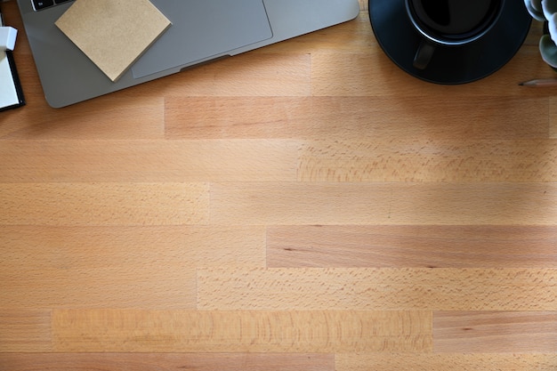 Houten werktafel met laptop, koffie en kopie ruimte.