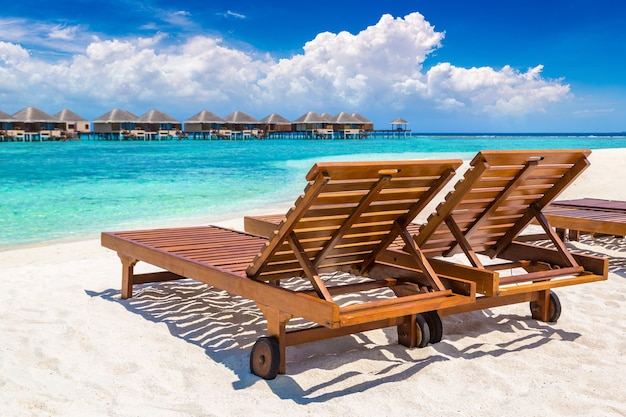 Houten zonnebank op tropisch strand in de Malediven