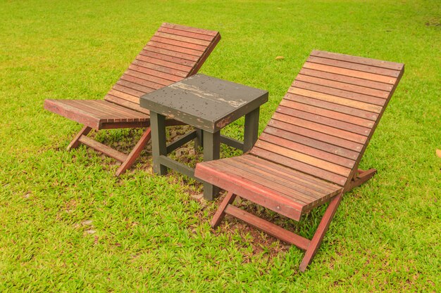 Houten zonstoel op groene tuin