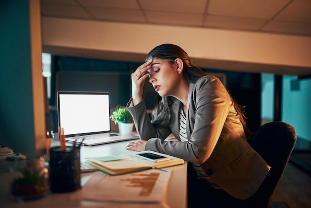 Photo how can i finish with this headache shot of a young businesswoman experiencing a headache in the office