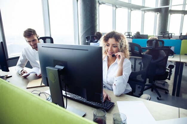 How can I help you? Female customer support operator with headset and smiling