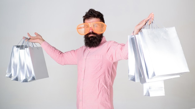 How to get ready for your next vacation. Man bearded hipster with lot shopping bags. Shopping on black friday. Happy shopping with bunch paper bags. Shopping addicted consumer. Profitable deal.