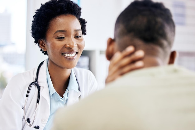 Photo how have you been feeling cropped shot of an attractive young female doctor doing consult with an unrecognizable male patient in her office