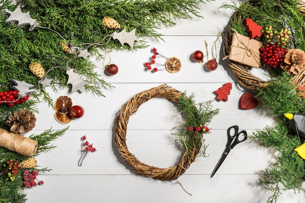 Come realizzare una ghirlanda per la porta di natale. il processo lavorativo. il posto di lavoro del decoratore. vista dall'alto. copia spazio. natura morta. disposizione piatta.