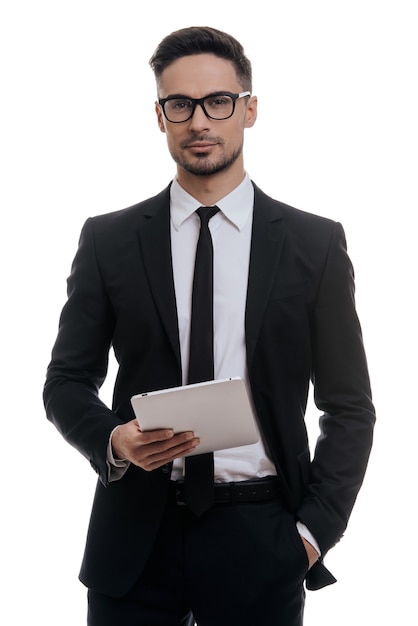 how may i help you?  good looking young man in full suit holding digital tablet and smiling 