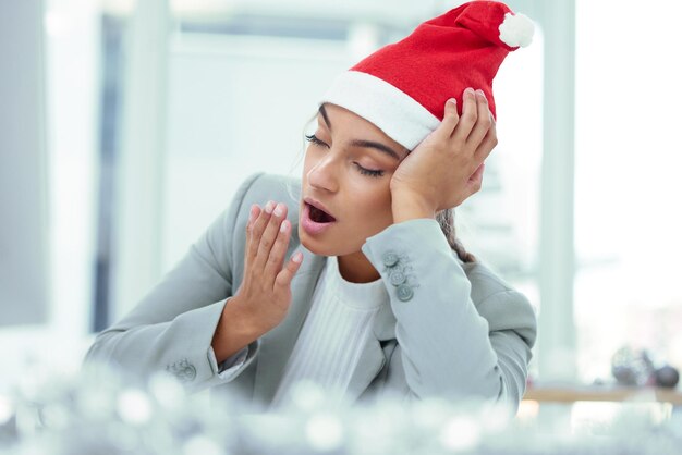 How much longer Shot of a sleepy woman yawning at her desk in the office