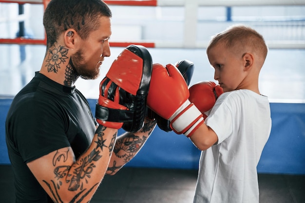 How to punch correct way coach is teaching the boy box\
techniques indoors