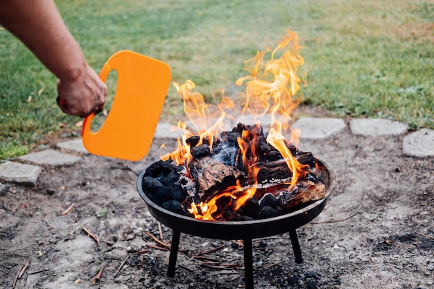 How to use a charcoal grill man with plastic bbq hand fan near charcoal grill fire barbeque plastic