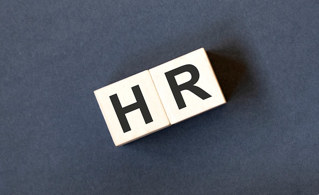 HR, Human Resources and recruitment concept by cube wooden block with alphabet building the word