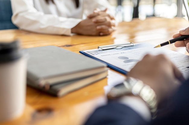 Photo the hr manager is interviewing job applicants. he is reviewing the eligibility of applicants from her resume. job interview ideas. the company is accepting employees for work and interview.