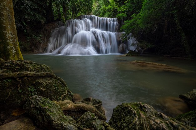 La cascata di hua mea khamin ha alberi tropicali, felci, crescita sulla cascata al mattino