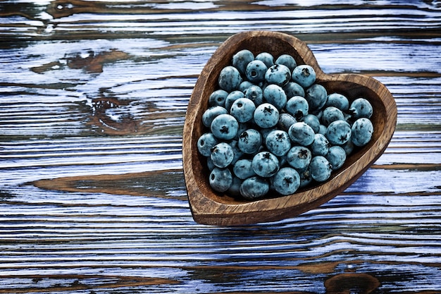 Huckleberries in wooden bowl on wood board