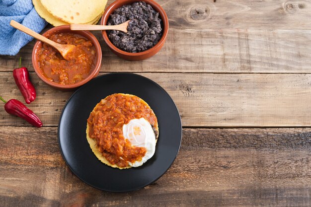 Huevos rancheros 요리, 나무 바닥에 멕시코 식 아침 식사. 멕시코 요리. 공간을 복사하십시오.