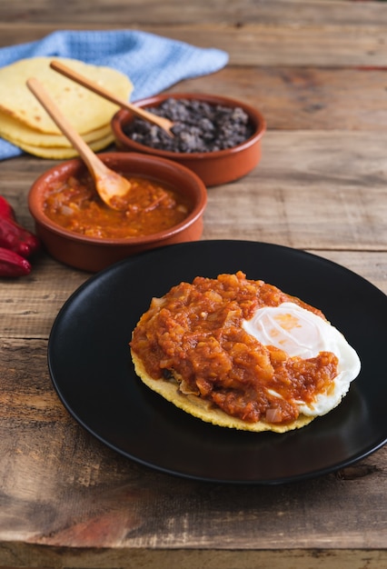 Huevos Rancheros gerecht, Mexicaans ontbijt op een houten voet. Mexicaanse keuken. Kopieer ruimte.