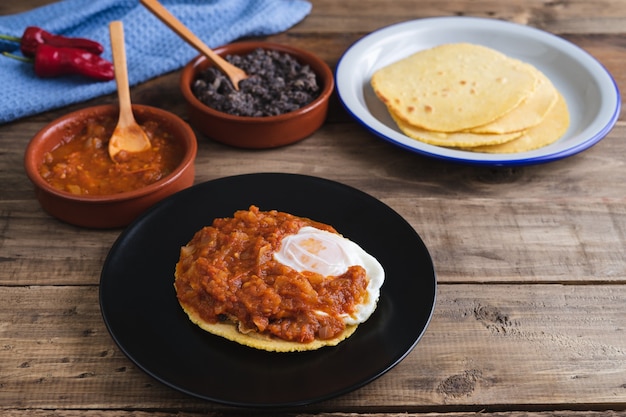 Huevos Rancheros gerecht, Mexicaans ontbijt op een houten voet. Mexicaanse keuken. Kopieer ruimte.