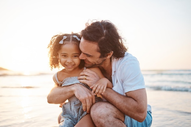 Hug portrait and a child and father at the beach for holiday care and love together after adoption Happy family and an interracial dad with a girl kid at the ocean for playing travel or vacation