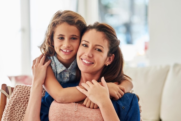 Hug portrait and mother with girl on sofa for love with connection affection and comfort with safety or security on mothers day Mom daughter and bonding together in home for support hug and care