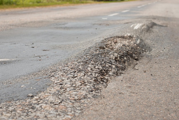 写真 路面の巨大な隆起と丘。道路の状態が悪い