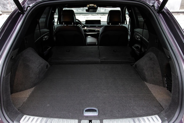 Огромный чистый и пустой багажник в салоне компактного внедорожника Вид сзади на внедорожник с открытым багажником