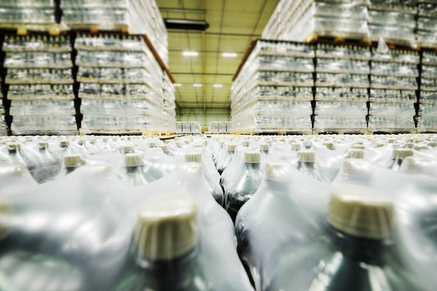 A huge industrial warehouse with plastic food wrap wrapped plastic bottles with carbonated drinks, water or beer.