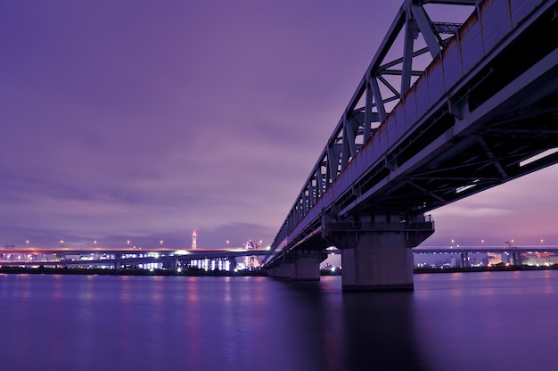 huge metallic railroad bridge over Arakawa river waters in Tokyo, Japan