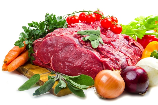 Pezzo di carne rossa enorme con verdure isolate su sfondo bianco