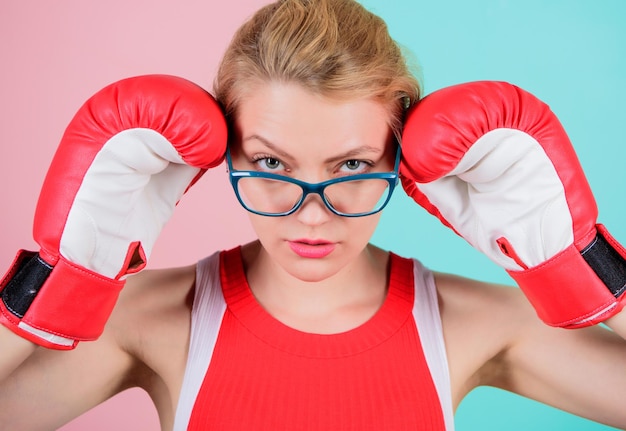 A huge sense of self confidence Sportswoman with nerdy look Pretty woman in glasses and boxing gloves Cute boxer girl Athletic woman in sports wear Boxing makes her super fit