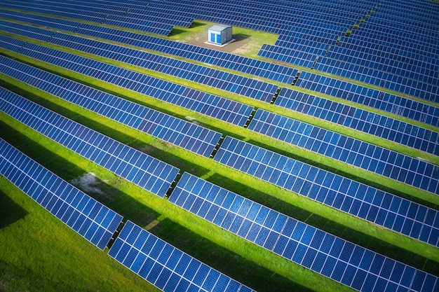 Huge solar power plant to use solar energy in a picturesque green field in Ukraine. Aerial panoramic drone shot