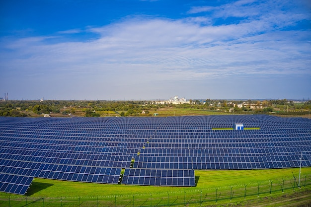 ウクライナの美しい緑の野原で太陽エネルギーを使用する巨大な太陽光発電所。航空写真