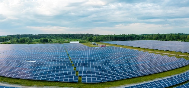 ウクライナの美しい緑の野原で太陽エネルギーを使用する巨大な太陽光発電所