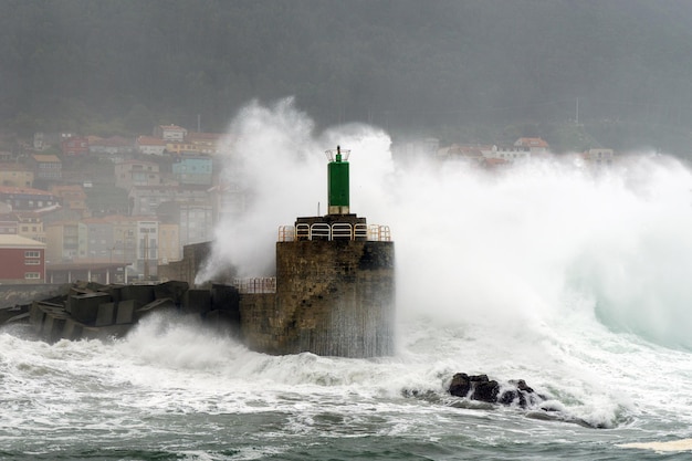 Huge waves breaking on the lighthouse of the port of A Guarda Spain