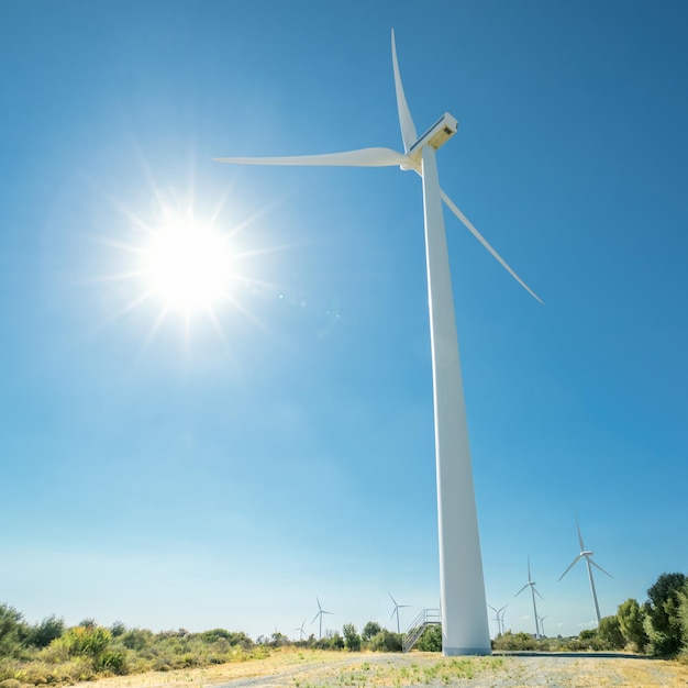 輝く太陽と青い空を背景にした巨大な風力発電機。キプロスのOreitesウィンドファーム