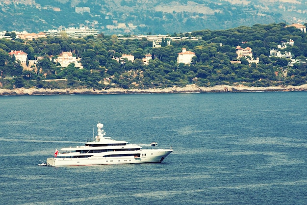 A huge yacht sails along the mountain area of the Principality of Monaco