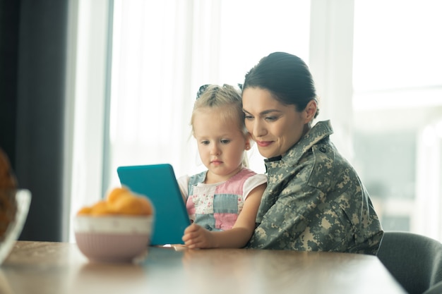 Hugging her child. Woman returning home after military service feeling happy hugging her child