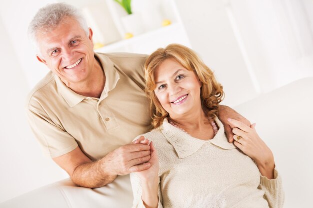 Hugging Senior couple in living room.