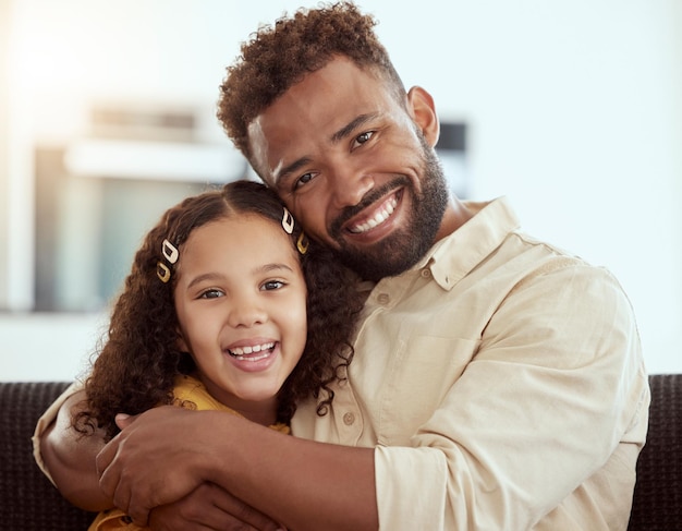 Hugging sofa and portrait of child with dad for love care and bonding together in home Smile connection and girl kid embrace single father for relax in living room on weekend at house in Colombia