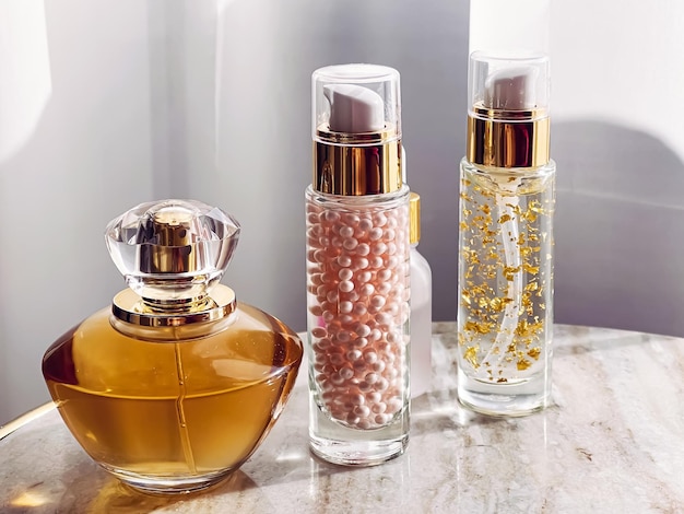 Huidverzorging en make-up cosmetica gouden serum emulsie flessen en parfum schoonheidsproduct close-up