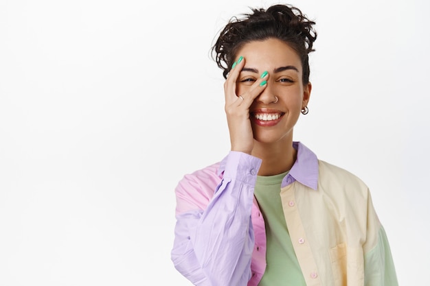 Huidverzorging en vrouwen concept. Mooie jonge vrouw met natuurlijke make-up huid, puur schoon gezicht aanraken, glimlachen en lachen op wit