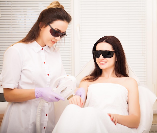 Huidverzorging Volwassen vrouw met laser ontharing in professionele schoonheidssalon