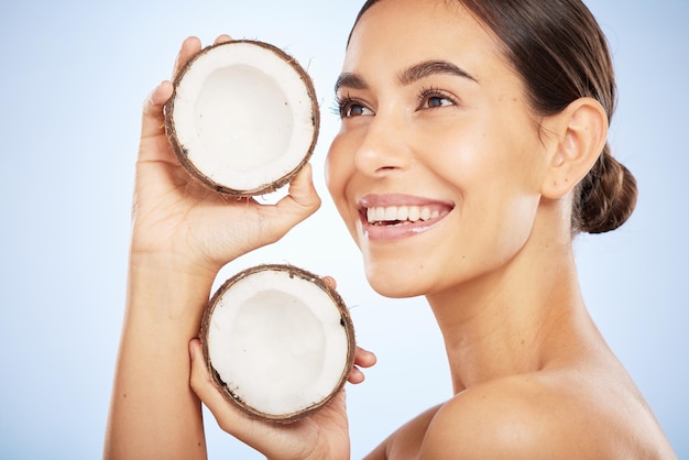 Huidverzorging wellness en gezicht van vrouw met kokosnoot op blauwe achtergrond voor dermatologie lichaamsverzorging en schoonheid Spa salon en meisje met fruit voor natuurlijke schoonheidsproducten cosmetica en gezichtsbehandeling