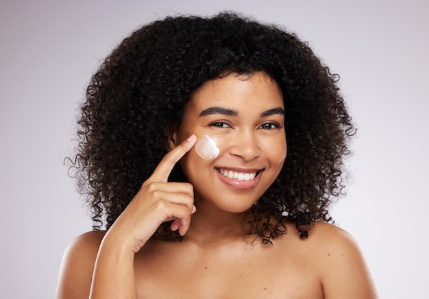 Huidverzorgingscrème en portret van zwarte vrouw voor schoonheid, wellness en huidgezondheid in studio Dermatologie luxe spa en gelukkig meisje met gezichtsbevochtiger voor anti-aging cosmetica en gezichtsbehandeling