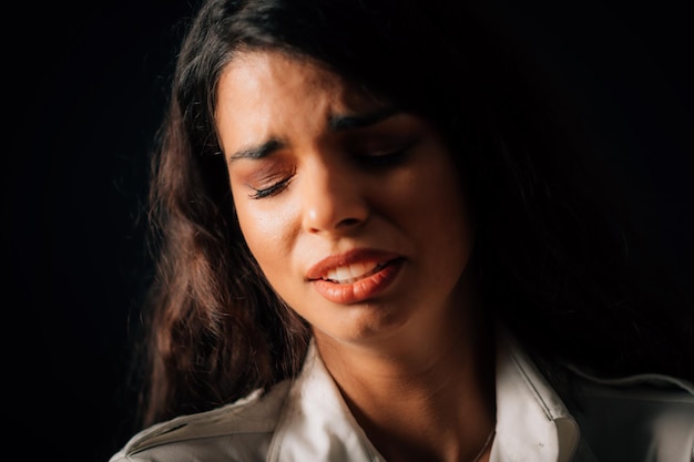 Huilend gezicht van een mooie trieste jonge vrouw huilende studio portret zwarte achtergrond