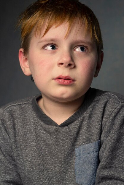 Foto huilende achtjarige jongen op een grijze achtergrond