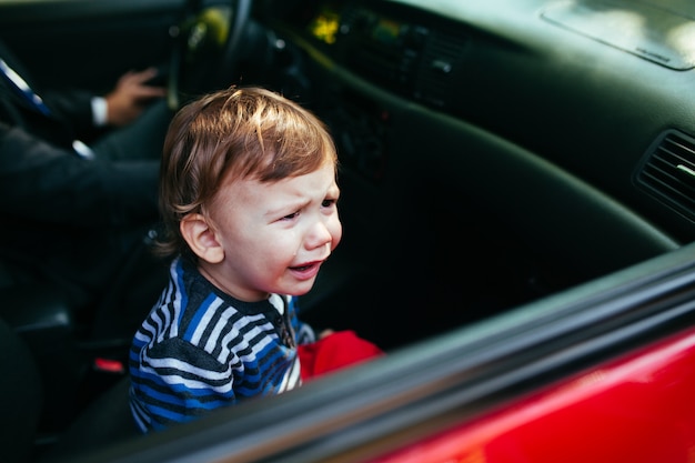 Huilende babyjongen in auto.