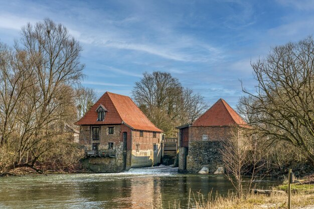 Huis bij het meer tegen de lucht in de winter