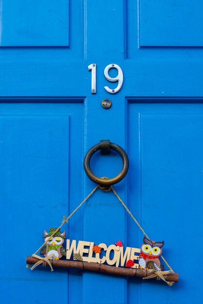 Foto huis nummer 19 op een blauwe houten voordeur