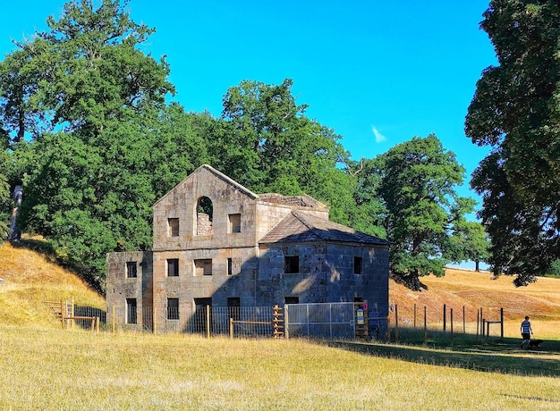 Foto huis op het veld tegen de blauwe hemel