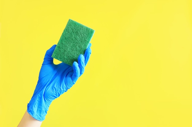 Huis schoonmaken Hand met een groene spons op een gele achtergrond Schoonmaak advertentie